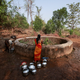 A resident fetches water from a well